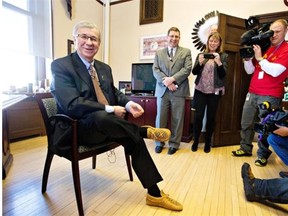 Alberta Finance Minister Robin Campbell tries on a new pair of moccasins during a pre-budget photo op in his office.
