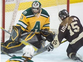 Alberta Pandas goalie Lindsey Post makes a save on Manitoba Bisons forward Maggie Litchfield-Medd during Game 1 of the Canada West women’s hockey final at Clare Drake Arena in Edmonton on March 6, 2015.