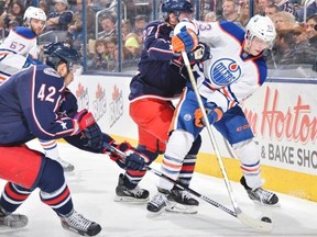 Artem Anisimov #42 and Ryan Murray #27 of the Columbus Blue Jackets attempt to knock the puck away from Ryan Nugent-Hopkins #93 of the Edmonton Oilers during the second period on March 13, 2015 at Nationwide Arena in Columbus, Ohio.