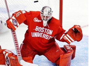 Boston University goalie Matt O’Connor deflects the puck on a save against North Dakota during the second period of a semifinal at the NCAA men’s Frozen Four hockey tournament in Boston, Thursday, April 9, 2015.