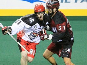 The Calgary Roughnecks’ Matthew Dinsdale, left, tries to fight off a check from the Colorado Mammoth’s Dan Coates during a National Lacrosse League game at the Scotiabank Saddledome in Calgary on Jan. 9, 2014.