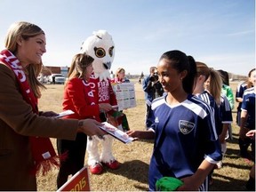 Canadian soccer superstar Kara Lang hands out tickets for the FIFA Women’ World Cup Canada 2015 to members of the Edmonton Strikers on April 13, 2015 in Edmonton.