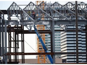 Construction workers use a man lift to do some high-up work on the new arena project in Edmonton on Saturday Feb. 7, 2015. Coun. Mike Nickel fears an economic slowdown will jeopardize the community revitalization levy, the fund that’s supposed to pay for the arena and other projects.