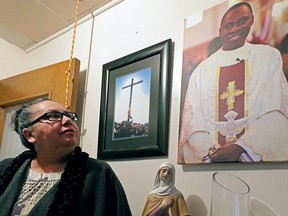 Patsy Hysell, a volunteer at Sacred Heart Roman Catholic Church on the Saddle Lake First Nation, looks at a portrait of Father Gilbert Dasna at the entrance of the church. Dasna was shot and killed in nearby St. Paul, Alta., on May 9, 2014.