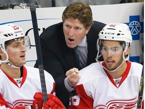 Detroit Red Wings head coach Mike Babcock, centre, gives instruction to Mattias Backman (25), and Ryan Sproul (48) in the first period of a NHL pre-season hockey game against the Pittsburgh Penguins in Pittsburgh on Sept. 22, 2014.