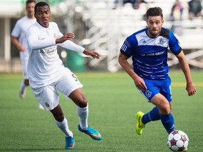 FC Edmonton's Ritchie Jones carries the ball up the field with Marlon Freitas of the Fort Lauderdale Strikers hot on his tail during North American Soccer League play at Clarke Stadium in Edmonton on April 19, 2015.