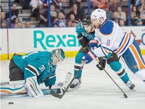 Edmonton Oilers centre Derek Roy tries to get to a loose puck despite the efforts of Matt Nieto (83) and goalie Antti Niemi (31) of the San Jose Sharks at Rexall Place in Edmonton on April 9, 2015.
