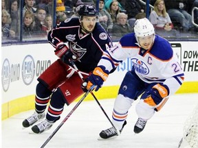 Edmonton Oilers defenceman Andrew Ference takes the inside track around the net with Columbus Blue Jackets’ Artem Anisimov in close pursuit during a National Hockey League game in Columbus, Ohio, on March 13, 2015.