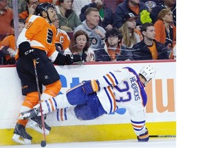 Edmonton Oilers’ Matt Hendricks is sent flying after a collision with Philadelphia Flyers’ Pierre-Edouard Bellemare during the first period of an NHL hockey game, Tuesday, Nov. 4, 2014, in Philadelphia.