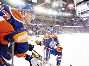 Edmonton Oilers’ Oscar Klefbom, left, helps defence partner Justin Schultz dig the puck out of the corner during a National Hockey League game against the St. Louis Blues at Rexall Place on Feb. 28, 2015.