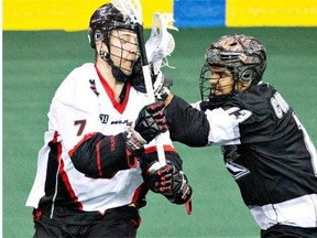 The Edmonton Rush’s Jeff Cornwall battles with the Vancouver Stealth’s Tyler Digby during NLL action at Rexall Place on March 14, 2015.