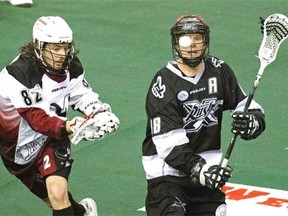 Edmonton Rush’s Zack Greer (right) and Colorado Mammoth’s Joey Cupido (left) keep their eyes on the ball during National Lacrosse League game action in Edmonton on Saturday, April 18, 2015.