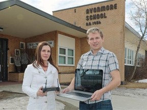 Edmonton Waldorf parent council member Jennie Marie Letwin, left, and parent council president Kevin Rudko stand in front of Avonmore School where students in the Waldorf program work on hard-wired computers in a part of the school that does not use Wi-Fi.