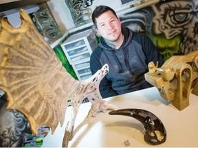 Fort McKay sculptor and artist Shawn McClure poses for a photo with his carved stone, caribou and moose antlers on Feb. 3, 2015.