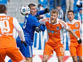 Frank Jonke of FC Edmonton, looks back at the ball while holding onto Connor Tobin of the Carolina RailHawks in North American Soccer League play at Clarke Stadium in Edmonton on April 12, 2015.
