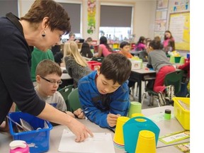 Grade 4 teacher Toni Sartorelli with Jameson Mann, left, and  Ethan Dube Estrada in math class