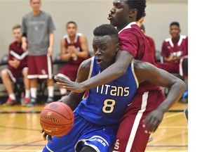 Harry Ainlay Titans guard Aher Uguak (8) battles an Archbishop O'Leary Spartans player during 4A Alberta senior boys provincials action at Jasper Place high school in Edmonton on March 19, 2015.