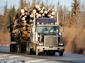 A heavily laden logging truck rumbles along Highway 2 southeast of Slave Lake on Tuesday Dec 13, 2011.