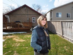Janick Hebert outside her backyard and her new infill neighbour. She says she didn’t have any flooding problems until the duplex was built in 2012.