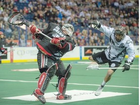 Jarrett Davis of the Edmonton Rush is taken out by goalie Frankie Scigliano of the Calgary Roughnecks in National Lacrosse League play at Rexall Placeon Saturday, April 11.