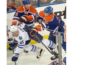 Keith Aulie (22) checks Leo Komarov (47) as the Edmonton Oilers play the Toronto Maple Leafs at Rexall Place in Edmonton on March 16, 2015.