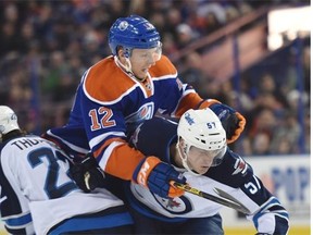 Rob Klinkhammer of the Edmonton Oilers unsuccessfully tries to split the Winnipeg Jets’ Chris Thorburn, left, and Tyler Myers in Monday’s National Hockey League game at Rexall Place.