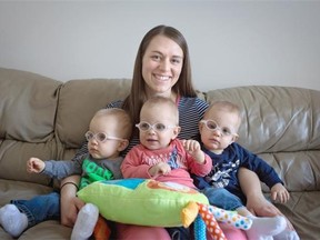 Leslie Low holds her triplets, from right, Luke, Mason, and Thomas, in their Edmonton home on February 4, 2015.
