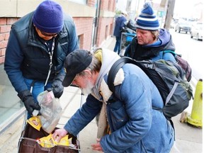 Mental health outreach workers hand out food to bottle collectors in Calgary’s beltline. Mark Holmgren of the Bissell Centre says Alberta needs a government that invests sufficient money to end poverty and homelessness.