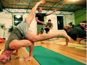 Mike Seibel (front) participates in a gay-friendly yoga class led by instructor Jason Morris (standing) at Lion’s Breath Yoga studio.