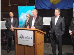 Minister of Transportation Wayne Drysdale, flanked by Premier Jim Prentice, right, announces the twinning of Highway 19 on April 1, 2015.