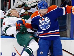 Minnesota Wild defenceman Stu Bickel, left, is hit by Edmonton Oilers defenceman Jeff Petry during NHL action on Jan. 27, 2015, at Edmonton’s Rexall Place.