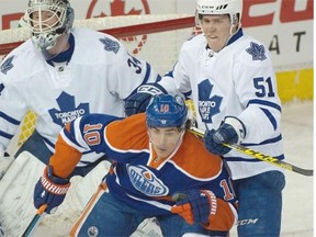 Nail Yakupov of the Edmonton Oilers takes a crosscheck in the neck from Toronto defenceman Jake Gardiner in front of Maple Leafs goalie James Reimer during Monday’s National Hockey League game at Rexall Place.