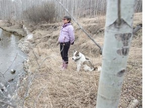Nancy Rempel walks with her dog Sherman near an erosion spot in the Mill Creek Ravine.