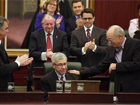 Robin Campbell (left), Alberta Minister of Finance, is congratulated by Alberta Health Minister Stephen Mandel (right) after Campbell delivered the provincial budget speech at the Alberta Legislature on March 26, 2015.