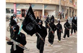 This undated file image posted on a militant website on Tuesday, Jan. 14, 2014 shows fighters from the Islamic State of Iraq and the Levant (ISIL) marching in Raqqa, Syria.
