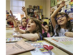 Students raise their hands to answer a question in this file photo.