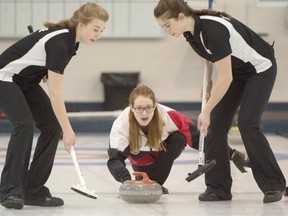 Ontario skip Kayla MacMillan lets go of her rock while Sarah Daviau, left, and Marcia Richardson sweep during the juvenile women’s final at the Optimist U18 curling championships at the Saville Centre in Edmonton April 5, 2015. Ontario won 4-1.