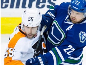 Philadelphia Flyers defenceman Nick Schultz fights for control of the puck against Vancouver Canucks forward Daniel Sedin during a National Hockey League game at Vancouver on March 17, 2015.