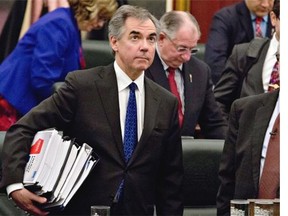Premier Jim Prentice carries budget documents after Finance Minister Robin Campbell delivered it in Edmonton on Thursday, March 26, 2015.