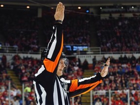 Referee Evgeny Romasko calls a penalty in the second period of an NHL hockey game between the Detroit Red Wings and the Edmonton Oilers in Detroit on Monday. Romasko is the first Russian referee in NHL history.
