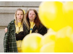 Renaye Wade and her mother Tammy wait to release yellow balloons from the front steps of the Alberta Legislature during a rally to raise awareness about distracted driving on March 15, 2015, in Edmonton.