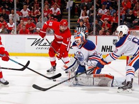 Riley Sheahan of the Detroit Red Wings waits for the puck to score his second-period goal behind against Edmonton Oilers goalie Ben Scrivens at Joe Louis Arena on March 9, 2015 in Detroit.