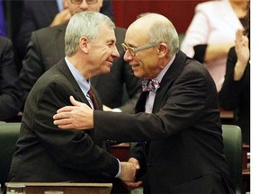 Robin Campbell (left), Alberta Minister of Finance, is congratulated by Alberta Health Minister Stephen Mandel (right) after Campbell delivered the provincial budget speech at the Alberta Legislature on March 26, 2015.