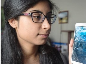Roshni Chadha, 20, looks at a photo of her car that was in a rollover crash on the weekend. She wants to find and thank the people who helped her.