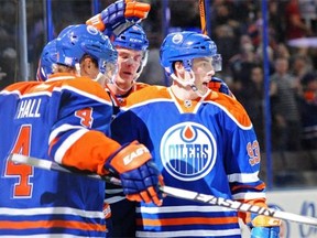 Ryan Nugent-Hopkins (93) of the Edmonton Oilers celebrates his goal on goalie Braden Holtby of the Washington Capitals with teammates Taylor Hall (4) and Mark Fayne (5) at Rexall Place in Edmonton on Oct. 22, 2014.