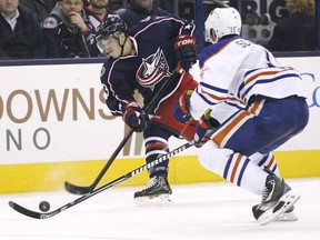 Columbus Blue Jackets Cam Atkinson shoots past Edmonton Oilers Nick Schultz in the second period of their NHL hockey game, Tuesday, March, 5, 2013, in Columbus, Ohio.