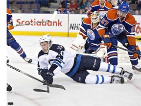 Winnipeg Jets John Albert (70) is knocked down by Edmonton Oilers David Musil (87) during first period NHL hockey action in Edmonton, on Monday September 29, 2014.