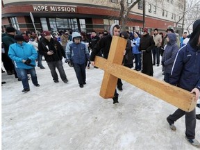 Taylor Marrit (left) and Derek Brown, both 16, carry the cross in front of the Hope Mission for an abbreviated version (due to weather conditions) of the 34th annual Good Friday Outdoor Way of the Cross in Edmonton on Friday, April 18, 2014.