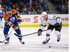 Teddy Purcell (16) of the Edmonton Oilers chases the puck down the ice with Tyler Toffoli (73) of the Los Angeles Kings during first-period action at Rexall in Edmonton on Dec. 30, 2014.