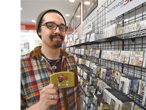 Terry Duncan, assistant general manager at Game City in West Edmonton Mall, holds a Zelda game for the Nintendo 64, one of the many vintage games that are growing increasingly popular.